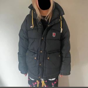 Svart dunjacka från Fjällräven - Säljer min svarta fjällräven jacka! Det är en äldre modell men sitter och ser ut som den nya. Ingen defekter eller något trasigt. Jätte skön och sitter perfekt!🤗