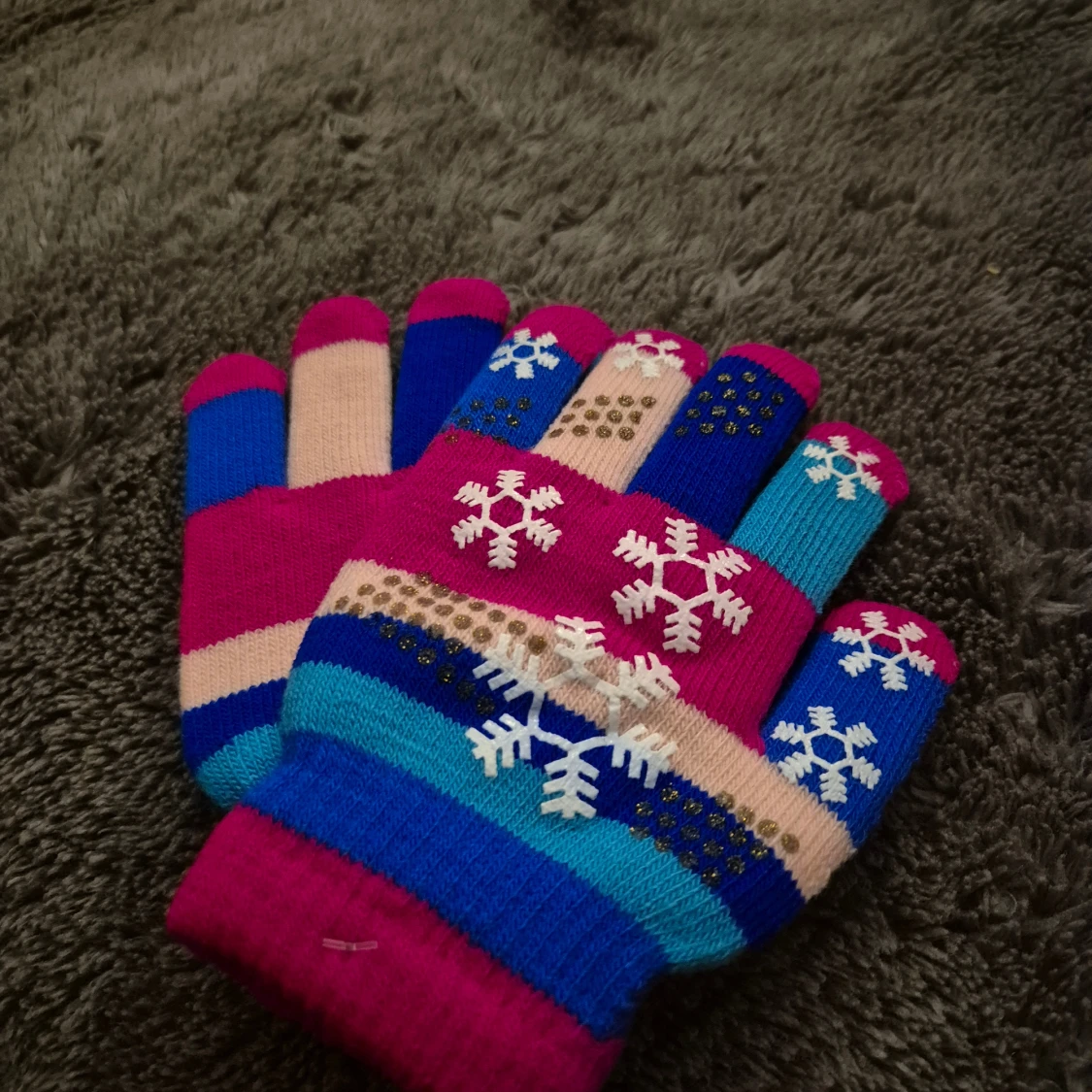 Färgglada stickade vantar med snöflingor