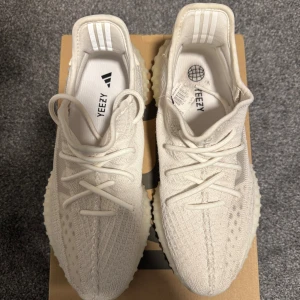 Adidas Yeezy Boost 350 V2 Cream White - Säljer ett par Adidas Yeezy Boost 350 V2 i färgen Cream White. Skorna har en stickad ovandel i syntet, snörning och en chunky, ribbad sula med boost-dämpning. Ikonisk siluett och diskret branding på insidan. Perfekta för dig som gillar clean och stilren streetwear.