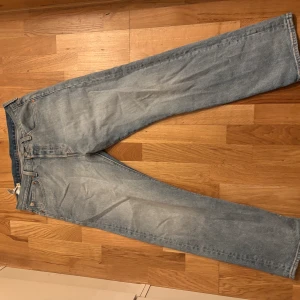 Levi's 501 ljusblå jeans W32 L30 - Klassiska Levi's 501 jeans i ljusblå tvätt med raka ben och normal passform. Jeansen har fem fickor, knappgylf och ikonisk läderpatch bak i midjan. Perfekta för en avslappnad och tidlös look.