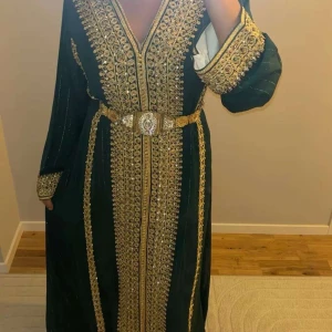 Mörkgrön långklänning med guldiga broderier - Marockansk klänning som har använts endast en gång, jätte fin silkes kvalité och i ny skick. 