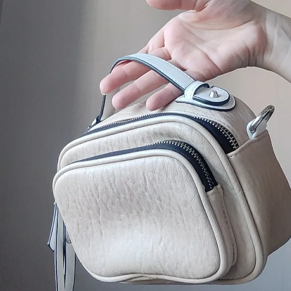 Beige väska i fakeskinn med vita och silvriga detaljer. Kan användas med eller utan axelrem, kan justeras och användas som midjeväska om man vill. ✨Köpare står för frakt på 66kr. . Väskor.