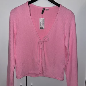 Rosa knyt kofta - Helt ny och oanvänd från hm, är mer som en XS/S i storleken men är väldigt stretchig i materialet. Hämtas i Ockelbo eller skickas mot att köparen betalar frakten. 