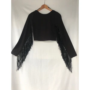 ZARA svart cropped top med fransar st.S - ZARA cropped top med fransar. Storlek 36. Fint skick, nästan som ny och inget att anmärka på.  Färg: mörkbrun/svart med svarta fransar. Längd: 40cm (cropped) Material: 95% bomull- 5%elastan  *RÖKFRI OCH DJURFRI HEM*
