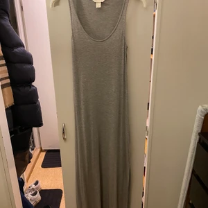Grå långklänning från H&M stl S - Enkel modell, slits upp till knät på ena sidan. Mjukt bomullsmaterial. Perfekt att ha till stranden eller en varm sommardag. Stl S. 