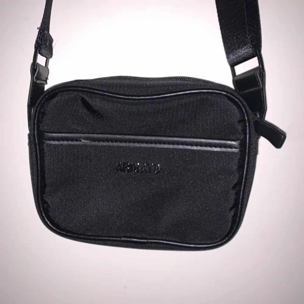 En svart axelremsväska från Axel Arigato med logo, använd ett fåtal gånger. Medkommer originalpåse! Nypris 800kr. Väskor.