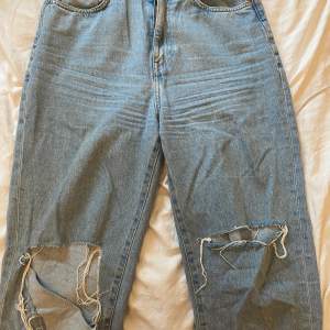 Blåa mom jeans med hål i båda knäna. Byxorna är från H&M och är i storlek 38. Är inte så använda eftersom dom är för stora men väldigt snygga 