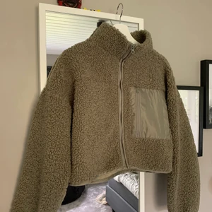 Jacka  - Kort teddyjacka ifrån Gina Tricot. Använd 1 gång, köpt i våras. Fin grön/militär- färg med ficka på bröstet. I storlek S.