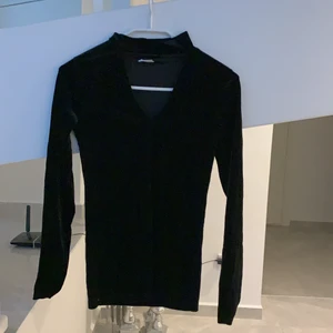 Svart samet tröja - En svart samet tröja med en fin v-ringning och polokrage