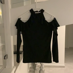 Svart topp - Svart topp med volanger och öppna armar