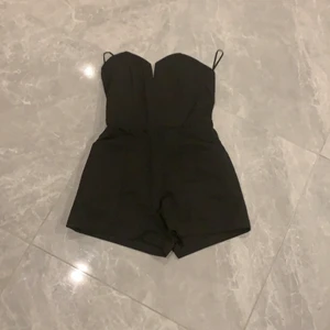 Svart jumpsuit - En oanvänd svart jumpsuit med prislapp på