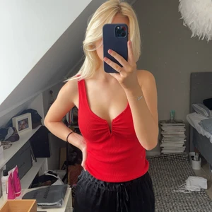 Rött linne med detalj fram - Rött snyggt linne med detalj framtill. Helt ny och oanvänd med prislapp kvar. Köpt för 119kr på ZARA, säljer för 90