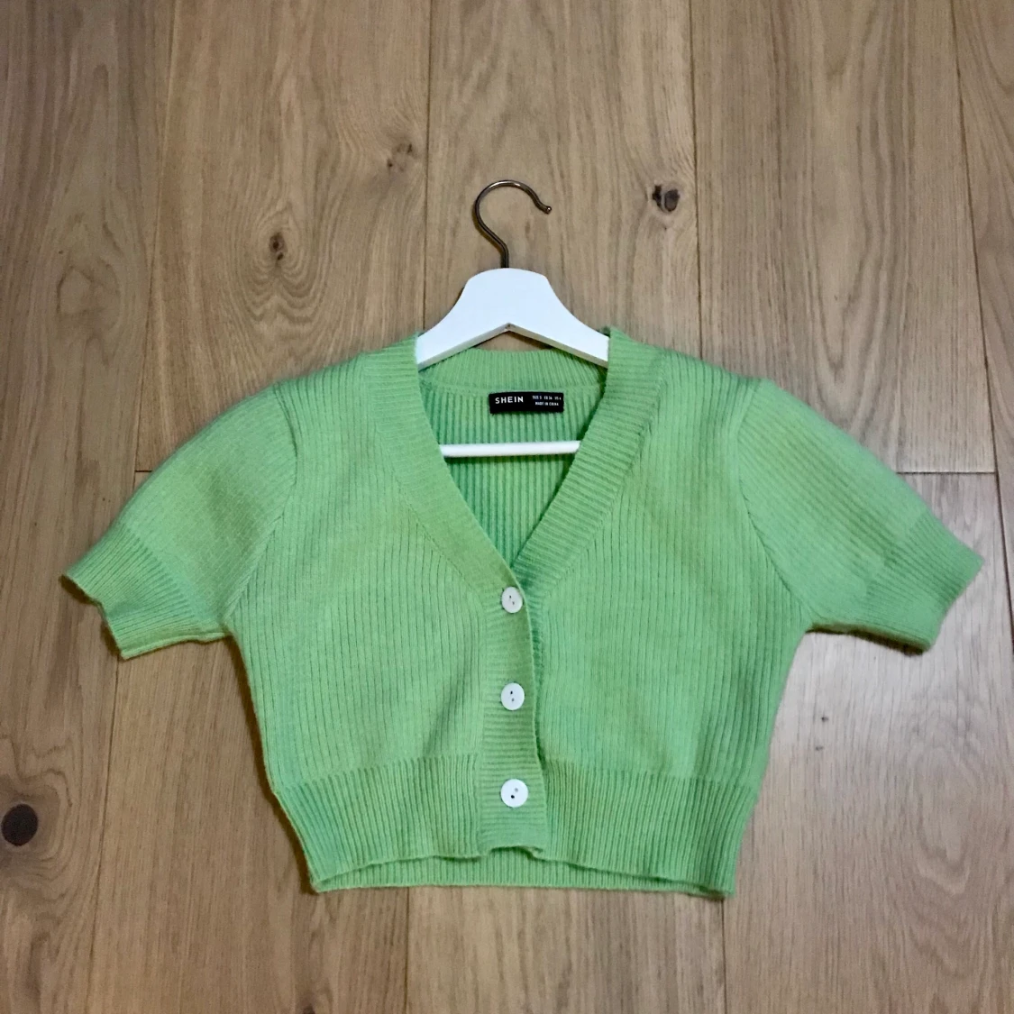 ljusgrön top med vita knappar i strl S - 91