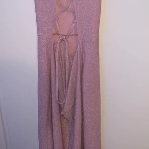 Rosa glitterklänning Storlek s/m - Denna är storlek L egentligen men passar enbart S/M då den sitter tight men en liten L fungerar! Rosa glittrig väldigt fin till fester och liknande. Slits vid benet som gör upp över knät, perfekt längd. Jag är 164 och längden på klänningen är bra och den släpar inte på golvet. Justerbara Knytband på ryggen med ett litet djup. Väldigt fin. Väljer ni att mötas blir det 40kr extra🥰❤️