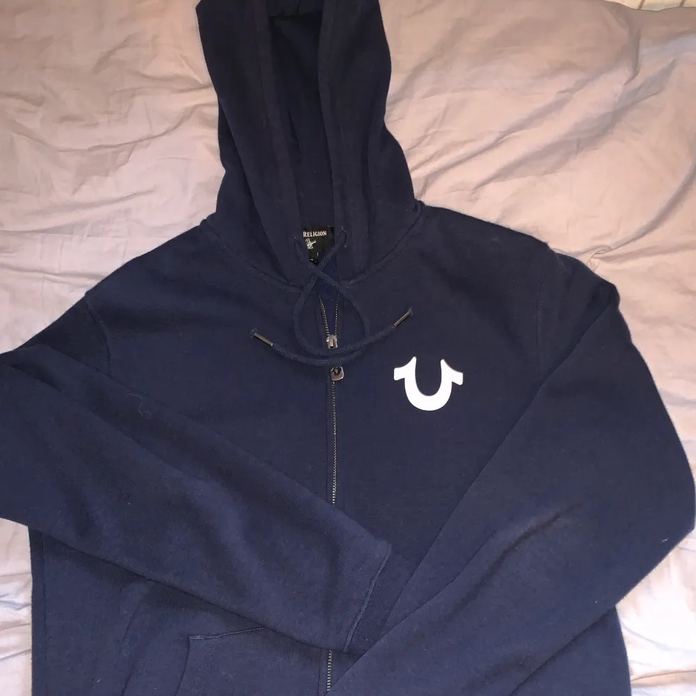 Trendig true religion hoodie som inte har använts mycket. Texten är i perfekt skick, Sitter lite oversize och är small, men kan passa medium beroende på vilken passform man vill ha. Nypris: 1400kr. Hoodies.