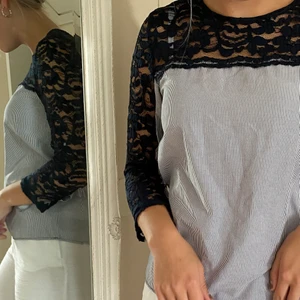 Topp från Zara - Jag säljer denna blå och vit randiga topp med spets längs armarna som även har knytdetaljer vid handlederna.