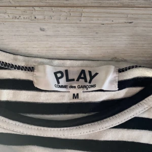 CDG play longsleeve - Tröjan är strl medium från början men har krympt extremt mycket i tvätten, den har krympt till ungefär S/XS och passar folk runt 155cm/160cm, tröjan är köpt på paul & friends inne på NK och har inte använts på över 2 år. Tröjan är i bra skick och säljer den pga att den har krympt och vill helst bli av med den. pris kan diskuteras