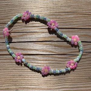 Armband med blommor - Armband jag gjort själv av pärlor. Armbandet är i pastellfärger och har blommor på. I priset är frakten inräknad . 50kr