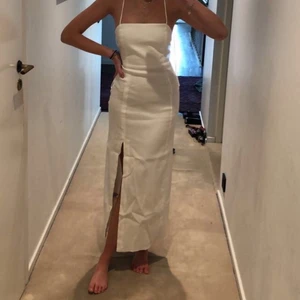 Helt ny klänning med slits och öppen ryg - Läng vit klänning från zara med öppen rygg och snörning, samr en slits. aldrig använd! Storlek xs, lappen är lvar