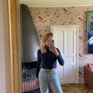 Långärmad tröja  - Mörkblå tröja som går lite högre upp i halsen. Ribbat material som är väldigt skönt och lite strechigt. Tröjan är lite cropad.             Frakt inkluderas inte i priset!