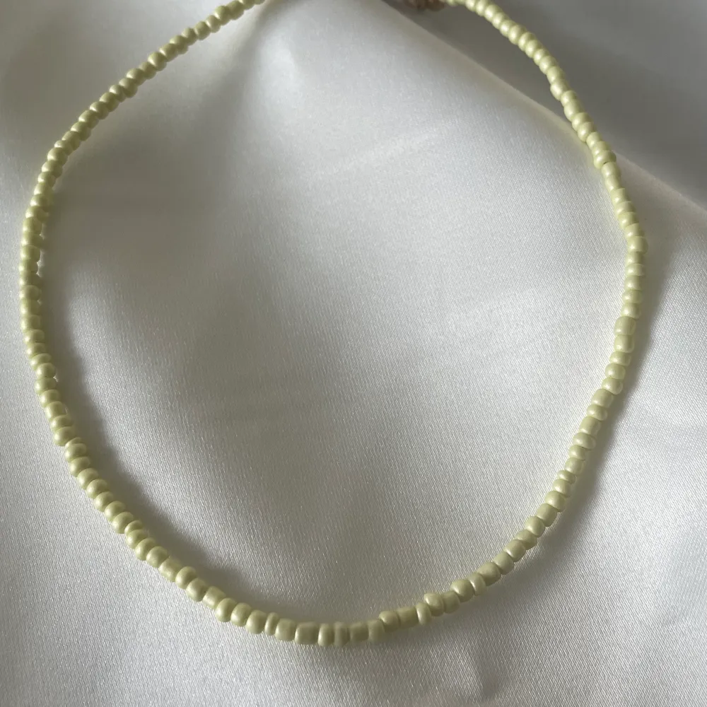 Pärl halsband med justerbart längd i bak och färg gul . Accessoarer.