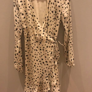 Neo noir sommarklänning - Sjukt snygg wrapklänning med volang i krämvit med mönster strl S. Köpte klänningen i somras för 1000kr