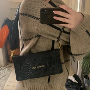 Michael kors väska - Säljer min väldigt gamla Michael kors väska som köptes på tidigt 2000 tal, använd fåtal gånger och väl omhändertagen. Stora och många fack i väskan vilket gör att du får plats med mycket! Den är i ormskin med gulddetaljer. 