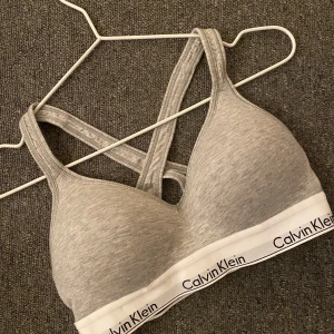CALVIN KLEIN TOPP  - En superfin och otroligt skön mjukare bh utan bygel i grått. Den är i fint skick, använd väldigt fåtal ggr då den inte passar i storleken 🤎✨  köpt för 500kr, säljer för 250kr + frakt 💕