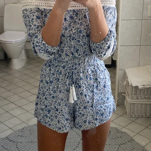 Blommig playsuit  - Blå och vit blommig playsuit. Använd endast 2 gånger! Kostade ca 700kr, där av priset. Köparen står för frakten 