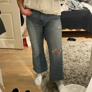 Jeans - Ett par lite pösiga ”bootcut” jeans i ljusblått. Sitter ovanför midan på mig! Storlek: 32