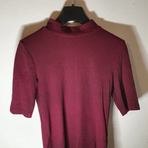 Vinröd polotröja - En vinröd tröja i gott skick,bortsett från att det finns lite ludd på tröjan. Köptes från H&M och är i storlek S. Mitt pris:30kr.