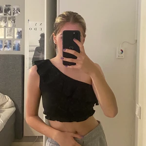 Topp - Croppad oneshoulder topp med volang runt hela.