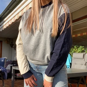 Crew neck hoodie  - Säljer denna sjukt coola, och helt nya hoodie med asymmetriska armar i beige och marinblå, alla lappar är kvar!!