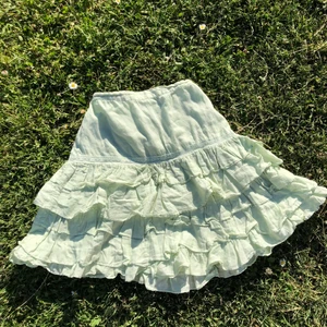 Kjol - Bohemisk kjol i underbar grön färg. perfekt för dig som söker en fairycore vibe! Barnstolen M, motsvarar storlek xs i damstorlek. Köpare står för frakt. Gott second hand skick