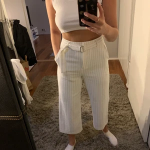 Sommarbyxor  - Vita byxor med tunna svarta sträck och bälte i midjan. Från HM och endast använda ett fåtal gånger. Perfekta till sommaren med en vit top eller stickad tröja.