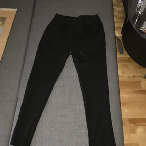 svarta byxor från lager 157 - stretchiga kostymbyxor från lager 157. storlek s - säljs då byxorna är för korta för mig (jag är 179 cm lång). använts endast två gånger. har framfickor och fejkade bakfickor. priset är allt som allt 166kr (priset på byxorna + frakt).