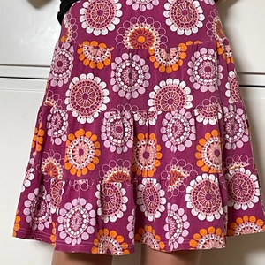 Lila/rosa kjol med mönster - Jättegullig lila/rosa sommarkjol med orangea, ljusrosa och vita mönster. Är i storlek S men den är ganska stretchig så passar nog en storlek mindre och större 😁. Den är i mycket bra skick och bekväm. Kontakta för fler bilder, frågor eller vid intresse :). Köparen står för frakten!