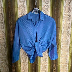 Skjorta/knytblus i thaisiden, OBS blå med rosa skimmer!  - Disco-dröm, denna half sleeve har en gång i tiden haft en lapp med stl L angivet - jag som har stl S har använt den som knytblus. Om en sätter elastiska band över armbågarna kan ärmarna draperas till en diskret puff sleeve. Ena ärmen har tappat en knapp, men en extra finns fastsydd på insidan! Underbart sval och luftig, flippad med cykelbyxor, höjdare med kjol, disco pants eller flared leggings. 