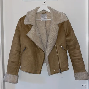 Bikerjacka med teddytyg  - Snygg beige bikerjacka med teddy detaljer. Klädd i mockaimitation på utsidan med creamfärgad teddytyg på insidan. Jackans längd är åt det kortare hållet och har silver detaljer. Står M men är mer som en S. Köparen står för frakt 💕