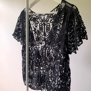 Svart broderad top storlek S/M - Svart supergullig broderad topp-ish som knyts med snöre framtill inköpt utomlands.  Storlek: saknar lapp för storlek men skulle säga den passar en S/M Pris: 60 + 66kr frakt.  100% bomull. Fint skick, inget att anmärka på!