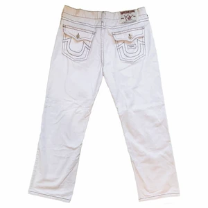 Vita True Religion jeans - Skitfeta jeans ifrån märket True Religion. Storlek 42 herrstorlek, men passar även mindre med bälte. Toppskick, inga defekter. Midjemått: 104 cm / Innerbenslängd: 84,5 cm / Ytterbenslängd: 119 cm