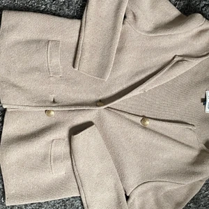 Kofta - Snygg kofta i beige med guldknappar. 