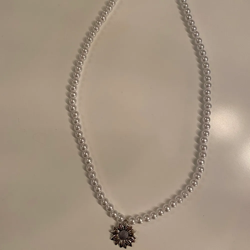 Egengjort halsband av vita pärlor med en berlock-blomma🌸. Accessoarer.