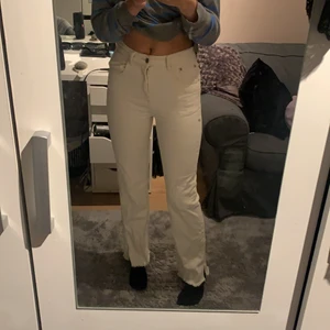 Vita jeans med slit - Vita/ ljus beiga jeans från pull & bear, rak modell med slit längst ner. Säljer pga av för små.