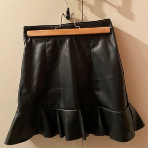 Svart skinnkjol - En svart skinnkjol med volang nertill. Köpt från H&M och den är endast provad. Prislappen finns kvar. Kan mötas i Stockholm eller skicka. Frakt: 66kr spårbart 🖤