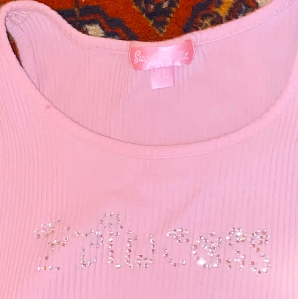 Rosa tank top med texten ”Princess” i rhinestones från Sugar Thrillz. Den har n liten färg fläck där bak, men går säkert bort om man kämpar. Toppar.