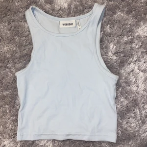 Ljusblått linne - Jag säljer detta väldigt fina ljusblåa linnet från weekday. Linnet är gjort av ett ribbad och stretchigt material som därför kan passa många olika storlekar. Den är knappt använd och i väldigt fint skick. Jag lägger ut denna igen pågrund av två oseriösa köpare. FRI FRAKT!!