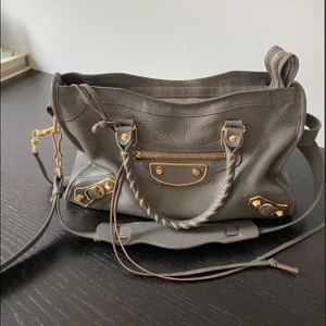 Balenciaga väska - Säljer nu min älskade balenciaga i superbra skick 🤍 Nypris på en sån här är ca 20.000kr men jag säljer den billigt då jag vill ha en snabb affär! Storlek Small - alltså den mellersta. Den är köpt på the Runway på TJ Maxx i USA och är därmed självklart äkta. Man får också med digitala kvittot, äkthetsbevis och dustbag 🤍 Sista bilden är för att visa hur storleken är. 