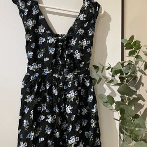 Sommarklänning - Säljer denna snygga sommarklänning. Klänningen är från Hollsister men har inget märke som syns förutom lappen på insidan. Den har snygga detaljer såsom resor baktill och öppet under brösten. Säljer den för 200 kr + frakt eller hämtas på Värmdö