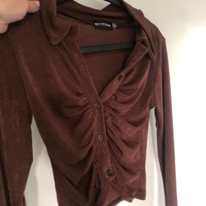 Brun topp  - Brun topp i ”slinky” material från Pretty Little Thing i storlek 36. Väldigt trendig topp som är helt slutsåld. 